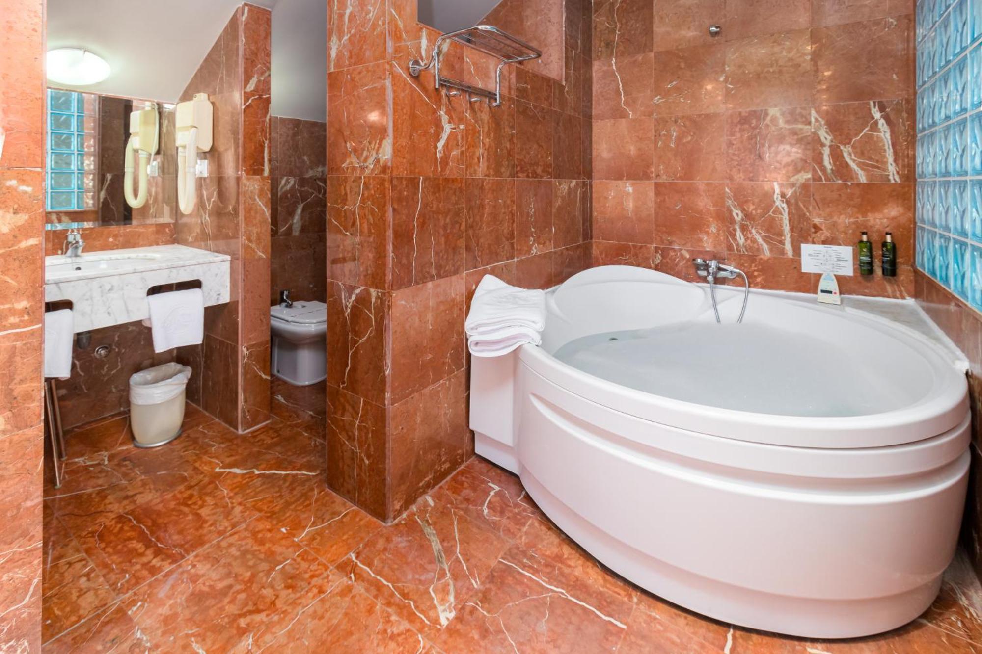 Suite con cama extragrande, bañera de hidromasaje y acceso al spa