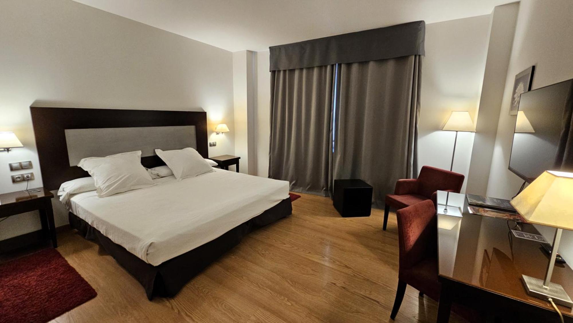 Habitación con cama extragrande y aparcamiento